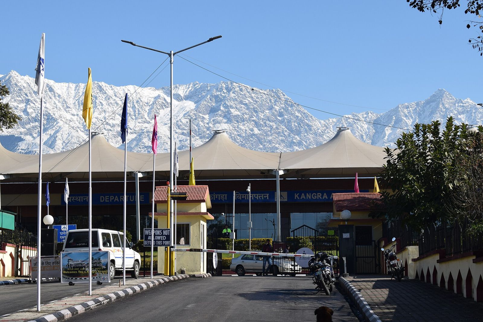 Kangra (Gaggal) Airport terminal entrance with the snow-covered Dhauladhar range rising behind
